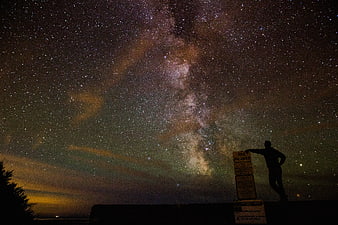 Silhouette of Man Pointing at Milky Way Galaxy at Night