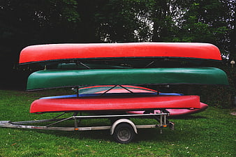 Stacked Canoes on Trailer in Grassy Field