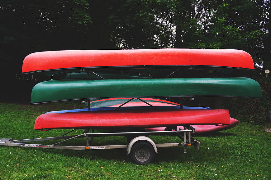 Stacked Canoes on Trailer in Grassy Field