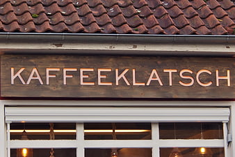 KaffeeKLATSCH wooden sign on traditional European cafe facade