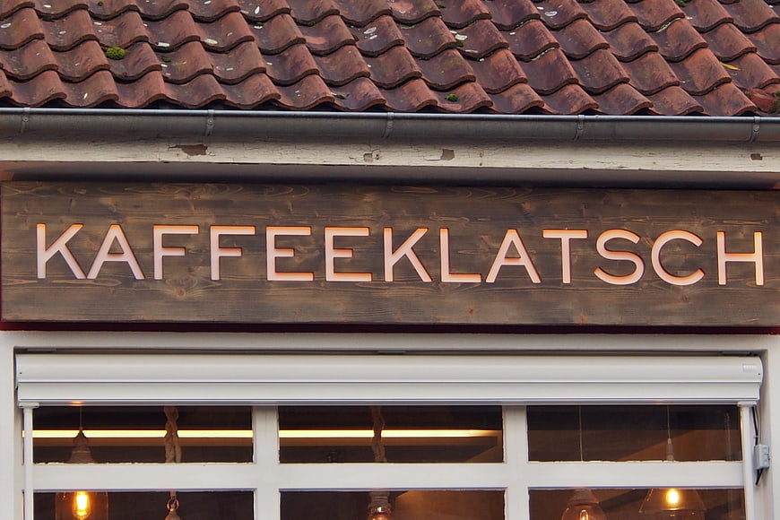 KaffeeKLATSCH wooden sign on traditional European cafe facade
