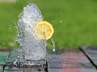 Refreshing Lemon Water Splash in Glass on Wooden Table