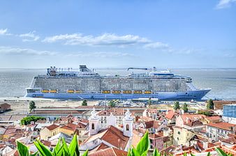 Cruise ship docked in Lisbon harbor with city rooftops