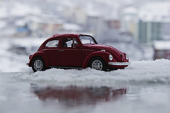 Red Vintage Toy Beetle Car in Snow with Reflection