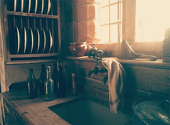 Vintage rustic kitchen sink with wooden shelves and antique bottles