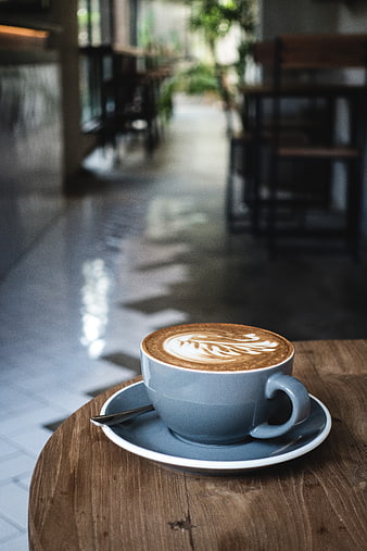 Blue Cup of Cappuccino with Latte Art on Wooden Table