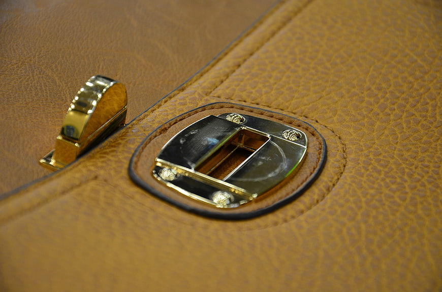 Close-up of brown leather bag with gold metal clasp