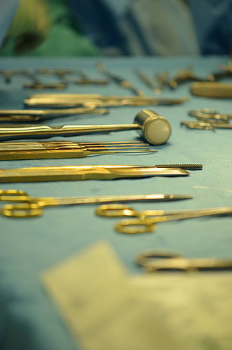 Gold Surgical Instruments On Blue Medical Table