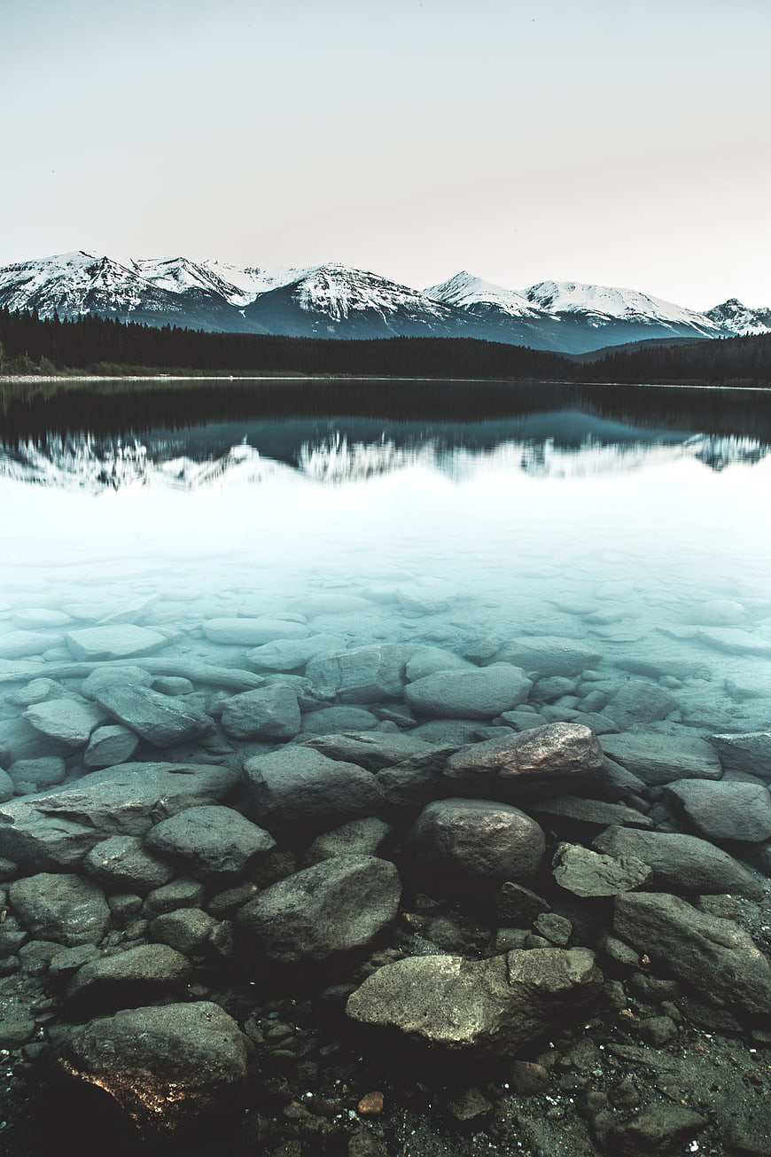 Serene Mountain Lake with Clear Rocky Shore and Reflections