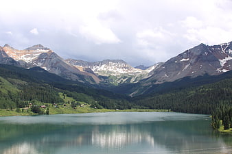 Scenic mountain lake with snow-capped peaks and pine forests