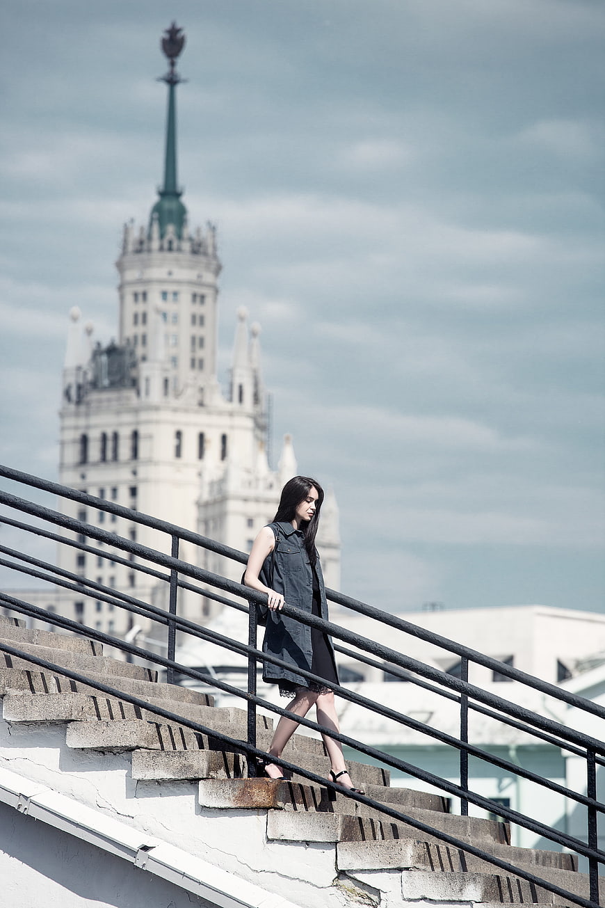 Young woman walking down stairs with Moscow skyscraper background