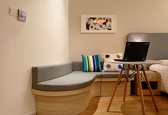 Modern Hotel Room Interior with Curved Sofa and Laptop