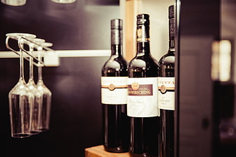 Wine bottles and glasses on a shelf in a bar
