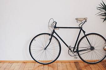 Vintage Black Road Bicycle Leaning Against White Wall