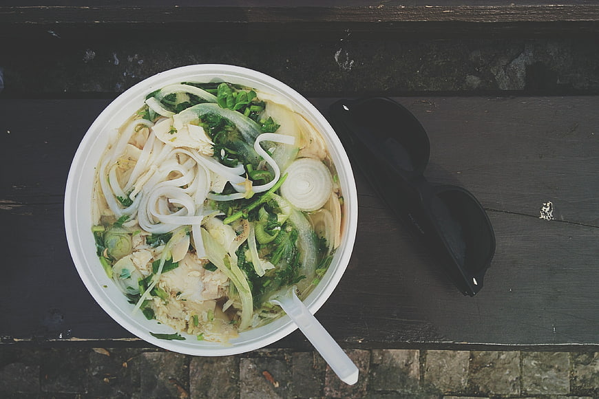 Top view of Vietnamese Pho Ga takeaway soup with sunglasses