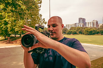 Male Videographer Filming in Urban Park