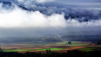 Misty Mountain Landscape with Patchwork Rice Fields and Clouds