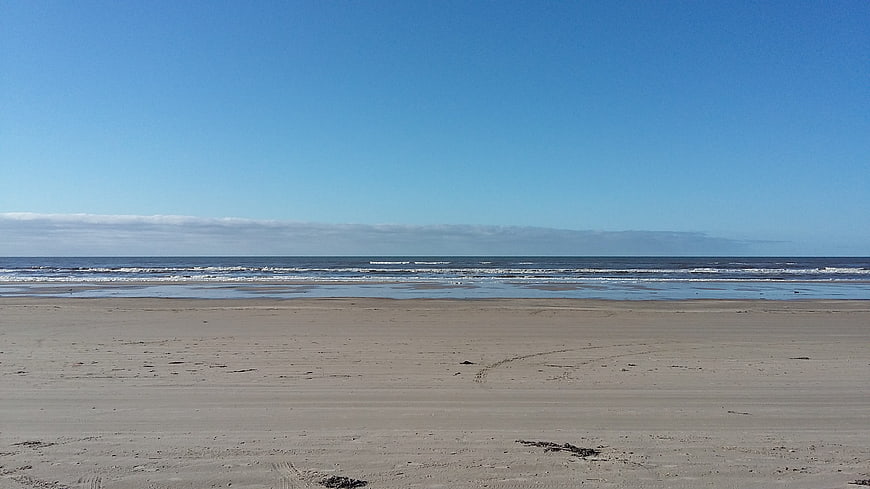 Wide Empty Sandy Beach with Blue Sky and Ocean Waves