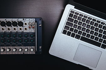 Audio Mixer and Laptop on Dark Desk