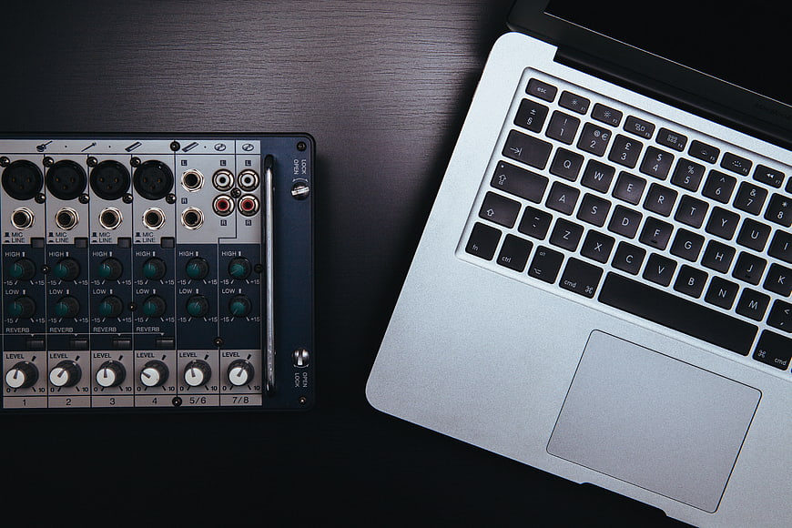 Audio Mixer and Laptop on Dark Desk