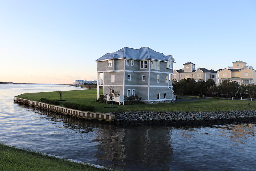 Modern waterfront house on a grassy peninsula at dusk