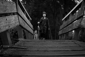 Black and white photo of children on a wooden bridge