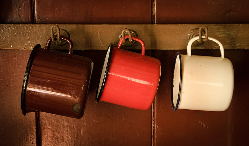 Vintage Enamel Mugs Hanging on Wooden Wall