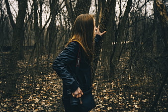 Woman with Camera Touching Tree in Autumn Forest