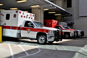 Row of parked emergency ambulances at fire station bay