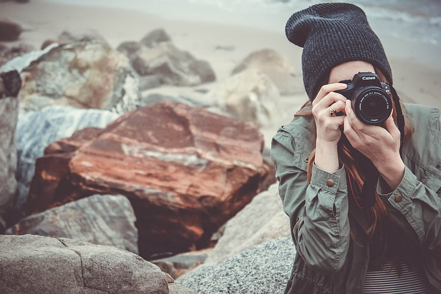 Woman Photographer Taking Pictures on Rocky Beach