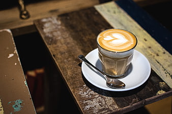Flat white coffee with latte art on rustic wooden table
