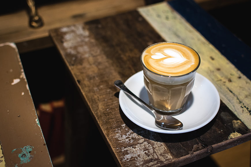 Flat white coffee with latte art on rustic wooden table