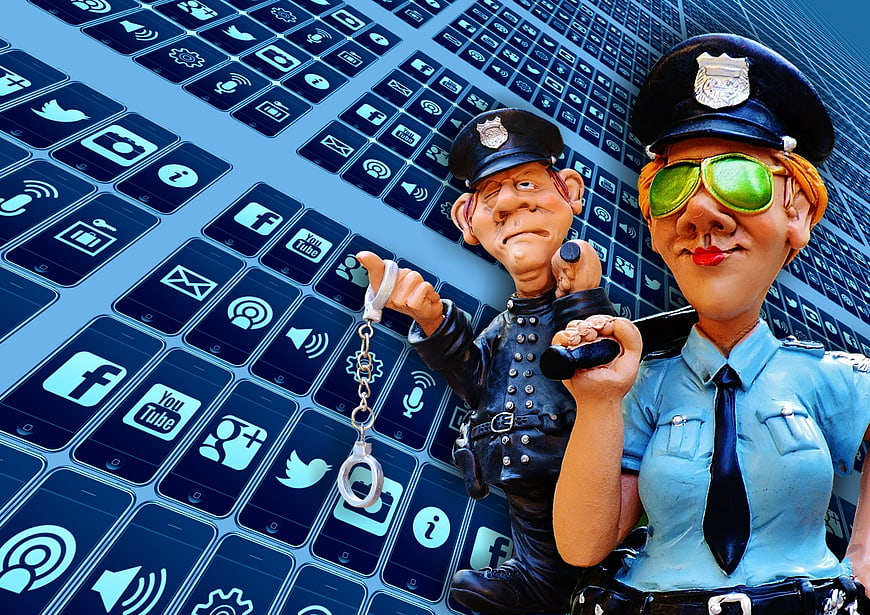 Police figurines with handcuffs and baton against social media icons background
