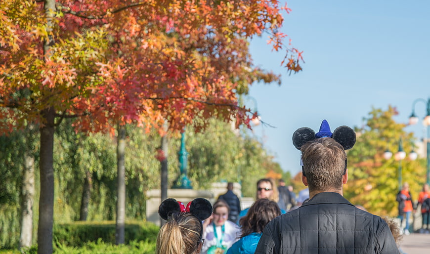 Back view of people wearing Mickey Mouse ears in autumn park