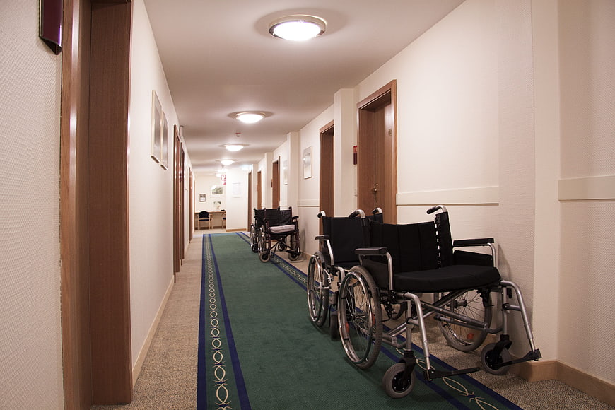 Empty hospital corridor with wheelchairs lined up against wall
