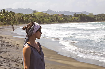 Woman with Headscarf Looking at Tropical Ocean Waves