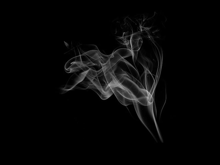 Abstract white smoke swirls against a black background
