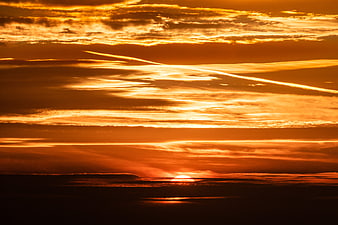 Dramatic Orange Sunset Sky With Layered Clouds And Horizon