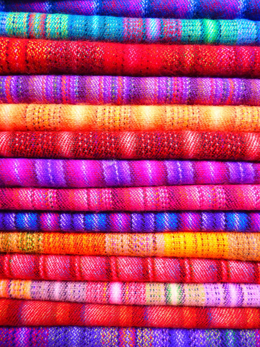 Vibrant Stacked Colorful Woven Textile Fabric Rolls