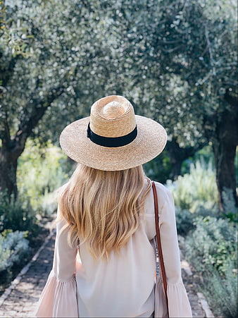 Woman in Straw Hat Walking Through Olive Grove