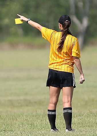 Female Soccer Referee Showing Yellow Card on Grass Field