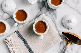 Overhead view of coffee cups on marble with linen napkin
