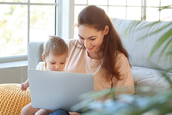 Mother and son using laptop at home