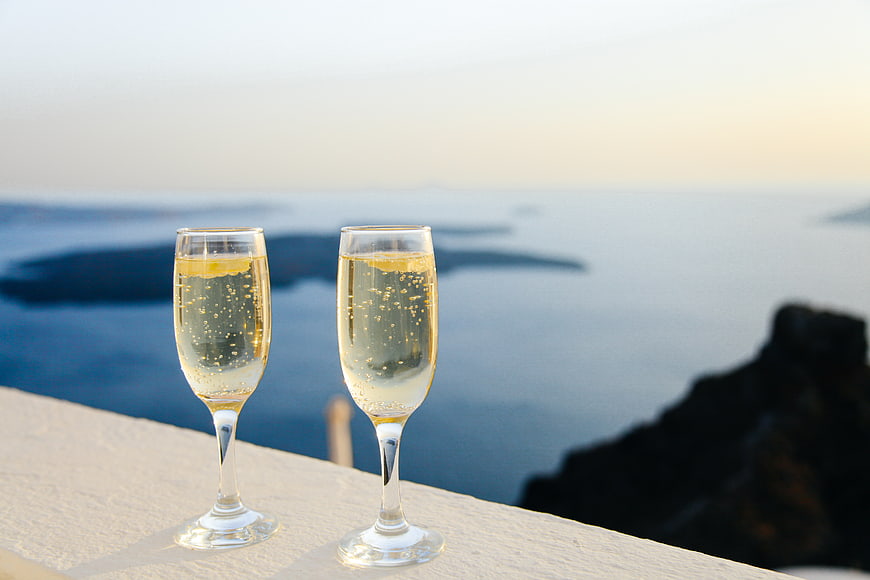Two glasses of champagne on a balcony overlooking the sea