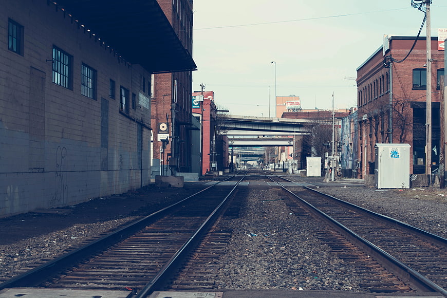Industrial railroad tracks leading through urban warehouse district