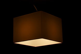 Modern square pendant lamp glowing in dark interior