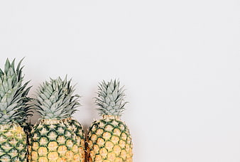 Three Ripe Pineapples on White Background with Copyspace