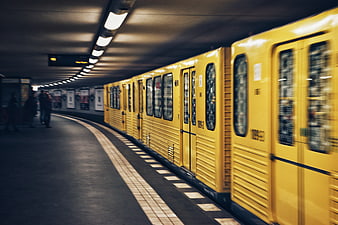 Yellow subway train arriving at underground station platform