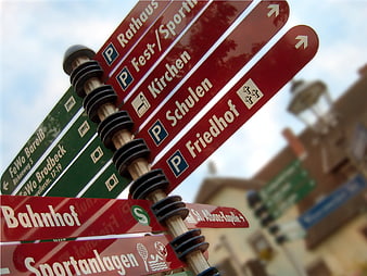 German Town Directional Signpost With Red And Green Signs