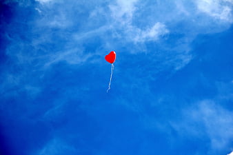 Red Heart Balloon Floating in Blue Sky